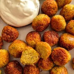 Goldbraune, knusprige Falafel, perfekt für ein veganes Rezept. Dazu cremiger Dip und frische Limette.