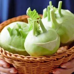 Frische Kohlrabi in einem Korb, bereit zur Lagerung. Die grünen Knollen mit ihren Stielen sind ein Zeichen für gute Qualität.
