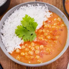 Herzhaftes veganes Kichererbsen-Curry mit Basmatireis, garniert mit Koriander. Ein köstliches Gericht für jeden Tag.