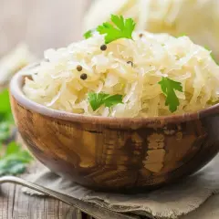 Schüssel mit Sauerkraut, garniert mit Petersilie und Pfefferkörnern. Ein gesundes Gericht, das die Verdauung fördert.