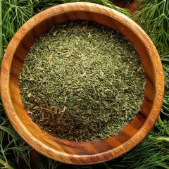 Get creative with dill: trocknen oder einfrieren für langanhaltenden Geschmack. Frische Dillzweige umrahmen eine Holzschale mit getrocknetem Dill.