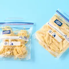 Zwei wiederverschließbare Beutel mit gekochten Nudeln: Spaghetti und Penne. Perfekt zum gekochte nudeln aufbewahren.