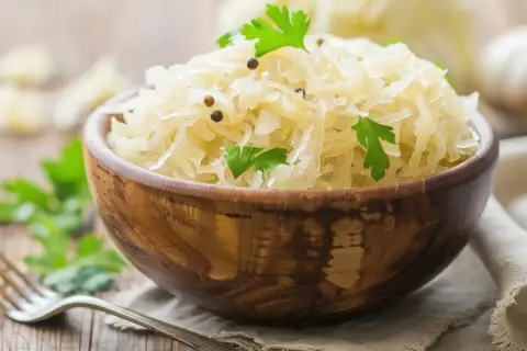 Schüssel mit Sauerkraut, garniert mit Petersilie und Pfefferkörnern. Ein gesundes Gericht, das die Verdauung fördert.