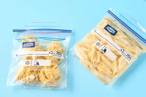 Zwei wiederverschließbare Beutel mit gekochten Nudeln: Spaghetti und Penne. Perfekt zum gekochte nudeln aufbewahren.
