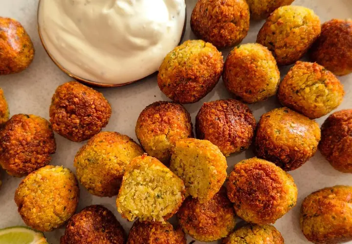 Goldbraune, knusprige Falafel, perfekt für ein veganes Rezept. Dazu cremiger Dip und frische Limette.