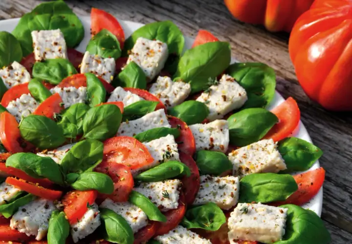 Frischer Tomaten-Mozzarella-Salat mit Basilikum, perfekt für ein veganes Party-Buffet.