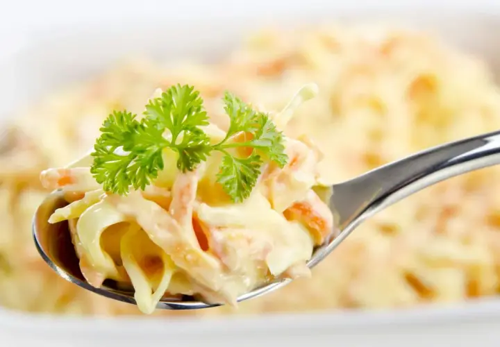 Ein Löffel cremiger Coleslaw Salat, garniert mit Petersilie. Perfekt für ein einfaches coleslaw salat rezept.