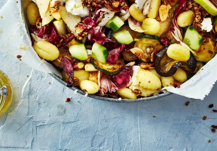 Ein köstlicher lauwarmer Gnocchi-Salat mit gegrilltem Gemüse, Radicchio, Birne und Nüssen, serviert mit Honig.