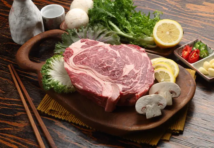 Rohes Rindersteak mit Pilzen, Zitrone und Kräutern. Wie lange kann man Rindfleisch einfrieren? Gut verpackt hält es Monate.