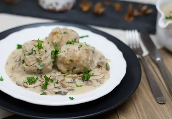 Vegane Semmelknödel in cremiger Pilzrahmsoße, garniert mit frischer Petersilie. Ein herzhaftes Gericht, das Lust auf mehr macht.