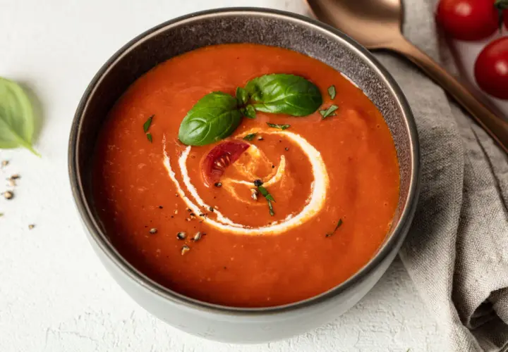 Eine cremige, vegane Tomatensuppe mit Basilikum und einem Klecks Sahne. Perfekt für kalte Tage.