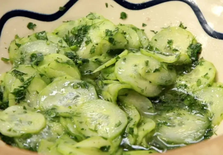 Frischer Gurkensalat ohne Essig, mit Dill und Petersilie, in einer Schüssel serviert.