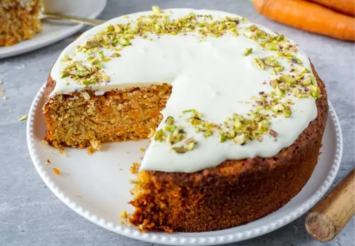 Saftiger Karottenkuchen mit Frischkäse-Frosting und Pistazien. Ein köstliches Beispiel für low carb backrezepte, das Genuss ohne Reue verspricht.