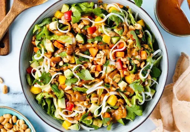 Bunter Sommerrollen Salat mit Reisnudeln, Mango, Avocado, Erdnüssen und cremiger Erdnusssauce.
