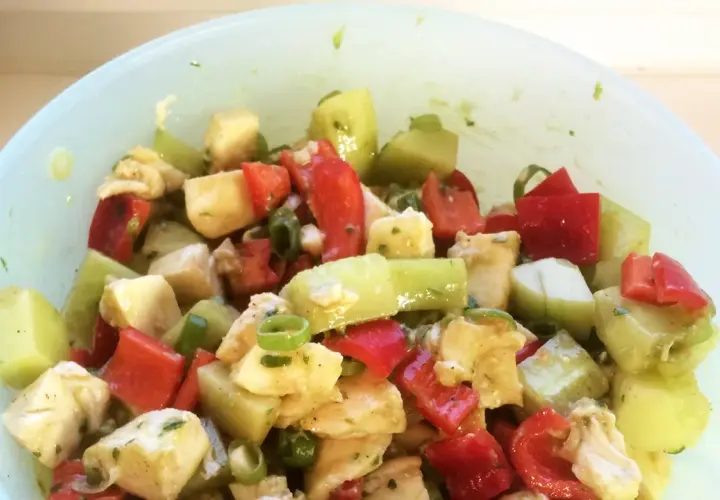 Frischer Salat mit gewürfeltem Gemüse und Käse, verfeinert mit Pesto.